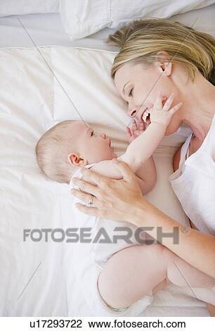 Stock Image - Mother and baby lying down together. Fotosearch