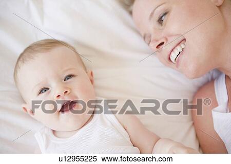 Mother and baby lying down together View Large Photo Image Stock Photography - Mother and baby lying down together. Fotosearch