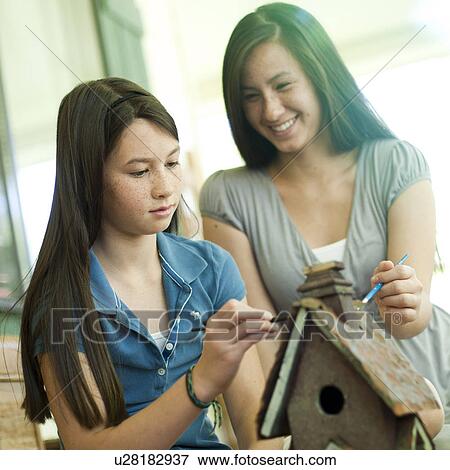 Stock Photo - Mother and daughter painting a birdhouse. Fotosearch