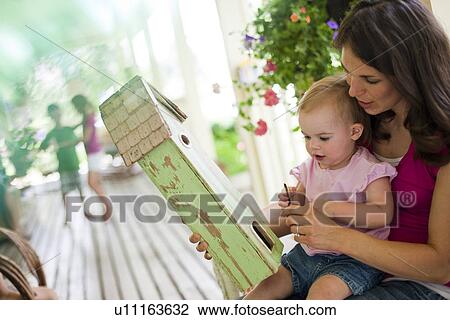 Mother daughter looking at birdhouse View Large Photo Image Stock Image - Mother daughter looking at birdhouse. Fotosearch