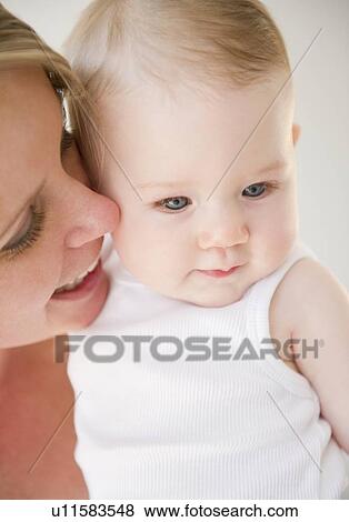 Stock Photo - Mother holding her baby daughter. Fotosearch