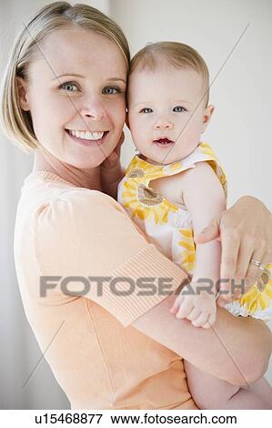 Mother holding her baby daughter View Large Photo Image Stock Photo - Mother holding her baby daughter. Fotosearch