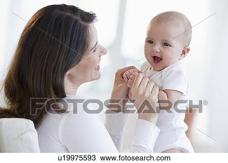 Stock Image - Mother holding her baby. Fotosearch