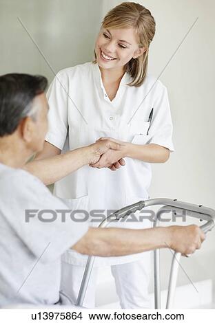 Picture - Nurse assisting patient with a walker. Fotosearch