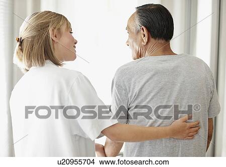 Picture - Nurse assisting patient with a walker. Fotosearch