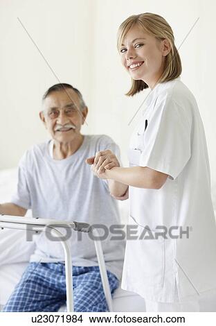 Picture - Nurse assisting patient with a walker. Fotosearch