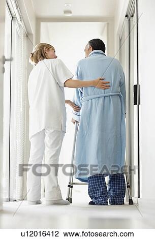 Nurse assisting patient with a walker View Large Photo Image Stock Image - Nurse assisting patient with a walker. Fotosearch