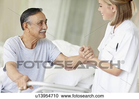 Stock Image - Nurse assisting patient with a walker. Fotosearch