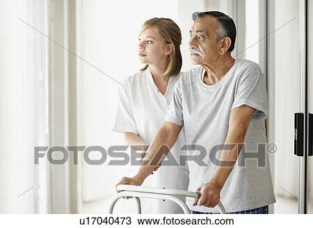 Stock Image - Nurse assisting patient with a walker. Fotosearch