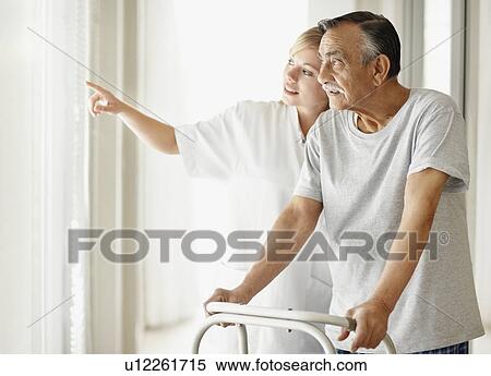 Nurse assisting patient with a walker View Large Photo Image Stock Photography - Nurse assisting patient with a walker. Fotosearch