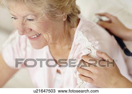 Stock Image - Nurse examining patient with a stethoscope. Fotosearch