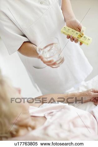Nurse giving pill to senior woman View Large Photo Image Stock Photography - Nurse giving pill to senior woman. Fotosearch