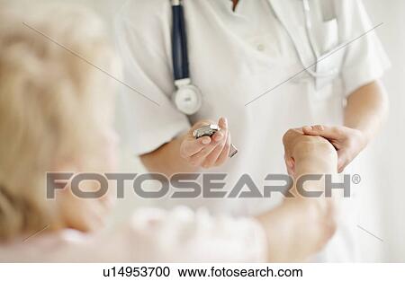 Nurse taking pulse of senior woman View Large Photo Image Stock Image - Nurse taking pulse of senior woman. Fotosearch