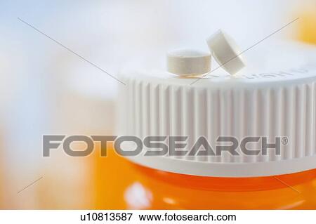 Pills on top of bottle of prescription medication View Large Photo Image Stock Photo - Pills on top of bottle of prescription medication. Fotosearch