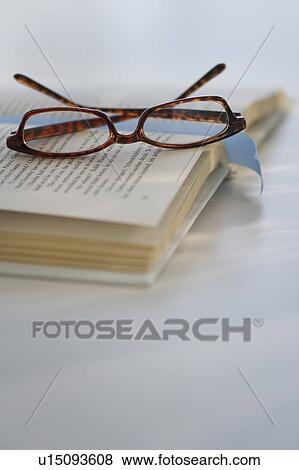 Reading glasses on book View Large Photo Image Stock Photo - Reading glasses on book. Fotosearch