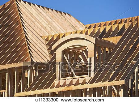 Stock Image - Roof framing of partially built house. Fotosearch