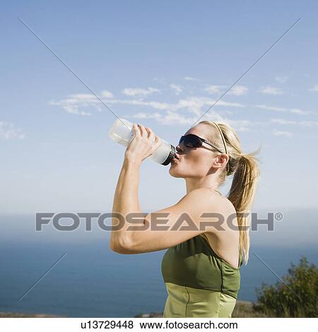 Runner having a drink of water View Large Photo Image Stock Photo - Runner having a drink of water. Fotosearch