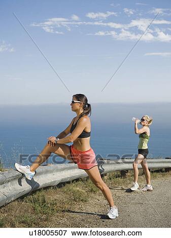 Stock Photo - Runner stretching on the side of the road. Fotosearch