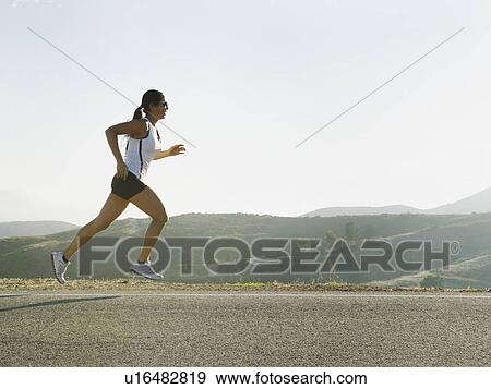 Stock Photo - Runner training on the side of the road. Fotosearch