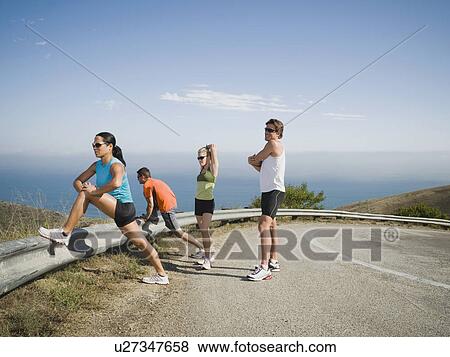 Stock Photo - Runners stretching on the side of the road. Fotosearch