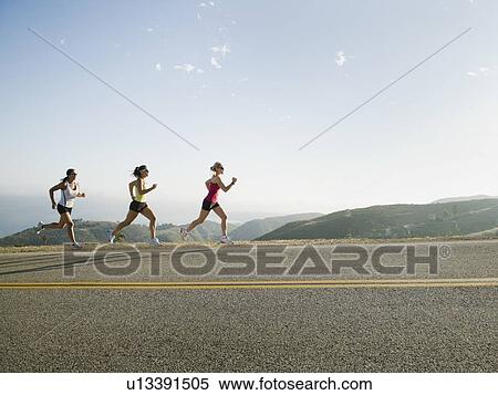 Stock Photography - Runners training on side of a road. Fotosearch