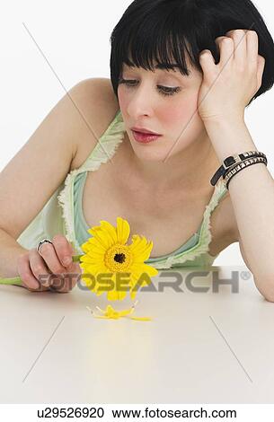 Stock Image - Sad woman holding a flower. Fotosearch