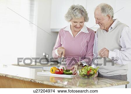 Picture - Senior couple preparing salad together. Fotosearch