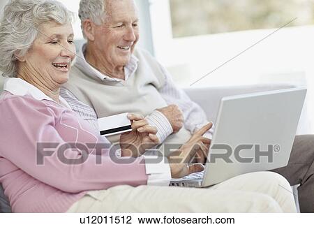Stock Image - Senior couple shopping online. Fotosearch