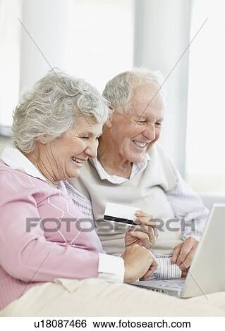 Stock Photograph - Senior couple shopping online. Fotosearch