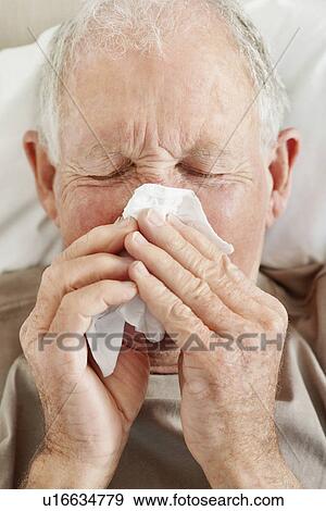 Stock Photo - Senior man blowing his nose. Fotosearch