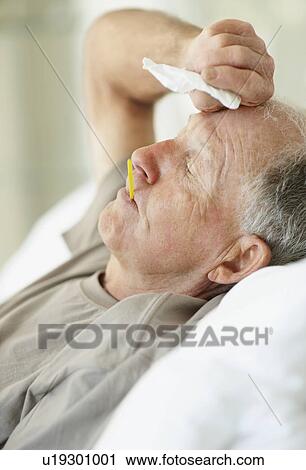 Senior man with a thermometer in his mouth View Large Photo Image Stock Image - Senior man with a thermometer in his mouth. Fotosearch