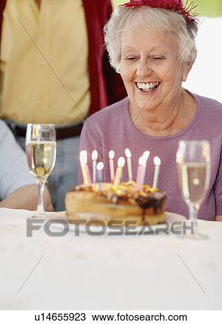 Stock Image - Senior woman at a birthday celebration. Fotosearch