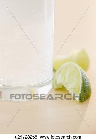 Stock Photo - Slices of lime beside glass of water. Fotosearch