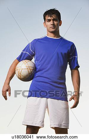Stock Image - Soccer player holding ball. Fotosearch