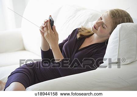 Sophisticated woman relaxing on couch View Large Photo Image Stock Photo - Sophisticated woman relaxing on couch. Fotosearch