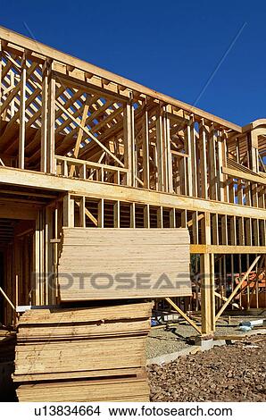 Picture - Stacks of plywood in front of house frame. Fotosearch