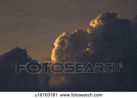 Stock Image - Sunset behind clouds. Fotosearch