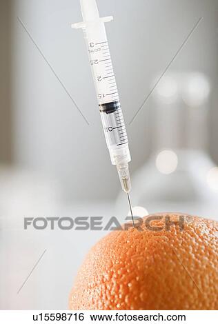 Stock Photograph - Syringe in orange. Fotosearch