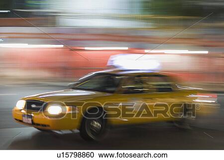 Stock Image - Taxi cab driving at night. Fotosearch