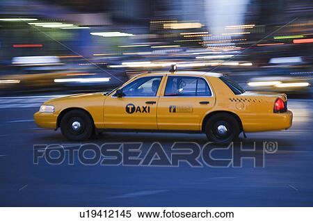 Stock Photography - Taxi cab driving in the evening. Fotosearch
