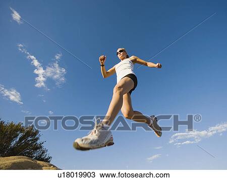Stock Image - Trail runner jumping. Fotosearch