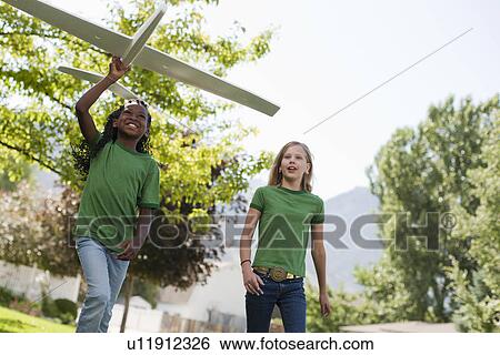 Two girls playing with toy airplane View Large Photo Image Stock Photograph - Two girls playing with toy airplane. Fotosearch