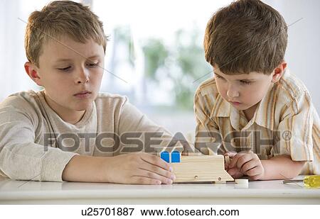 Stock Photo - Two young boys building a wooden train. Fotosearch