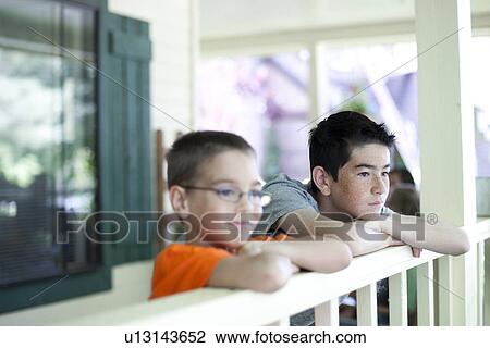 Two young boys gazing over railing View Large Photo Image Stock Image - Two young boys gazing over railing. Fotosearch