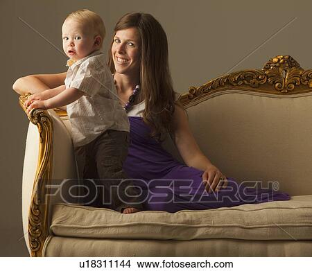 Picture - Woman and toddler sitting on antique sofa. Fotosearch