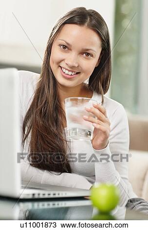 Stock Image - Woman drinking a glass of water. Fotosearch