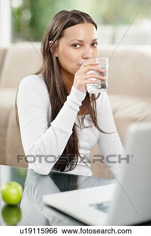 Woman drinking a glass of water View Large Photo Image Stock Photograph - Woman drinking a glass of water. Fotosearch