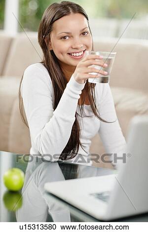 Woman drinking water while browsing the internet View Large Photo Image Stock Image - Woman drinking water while browsing the internet. Fotosearch