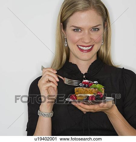 Stock Image - Woman eating decadent dessert. Fotosearch