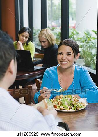 Stock Image - Woman eating salad in restaurant. Fotosearch